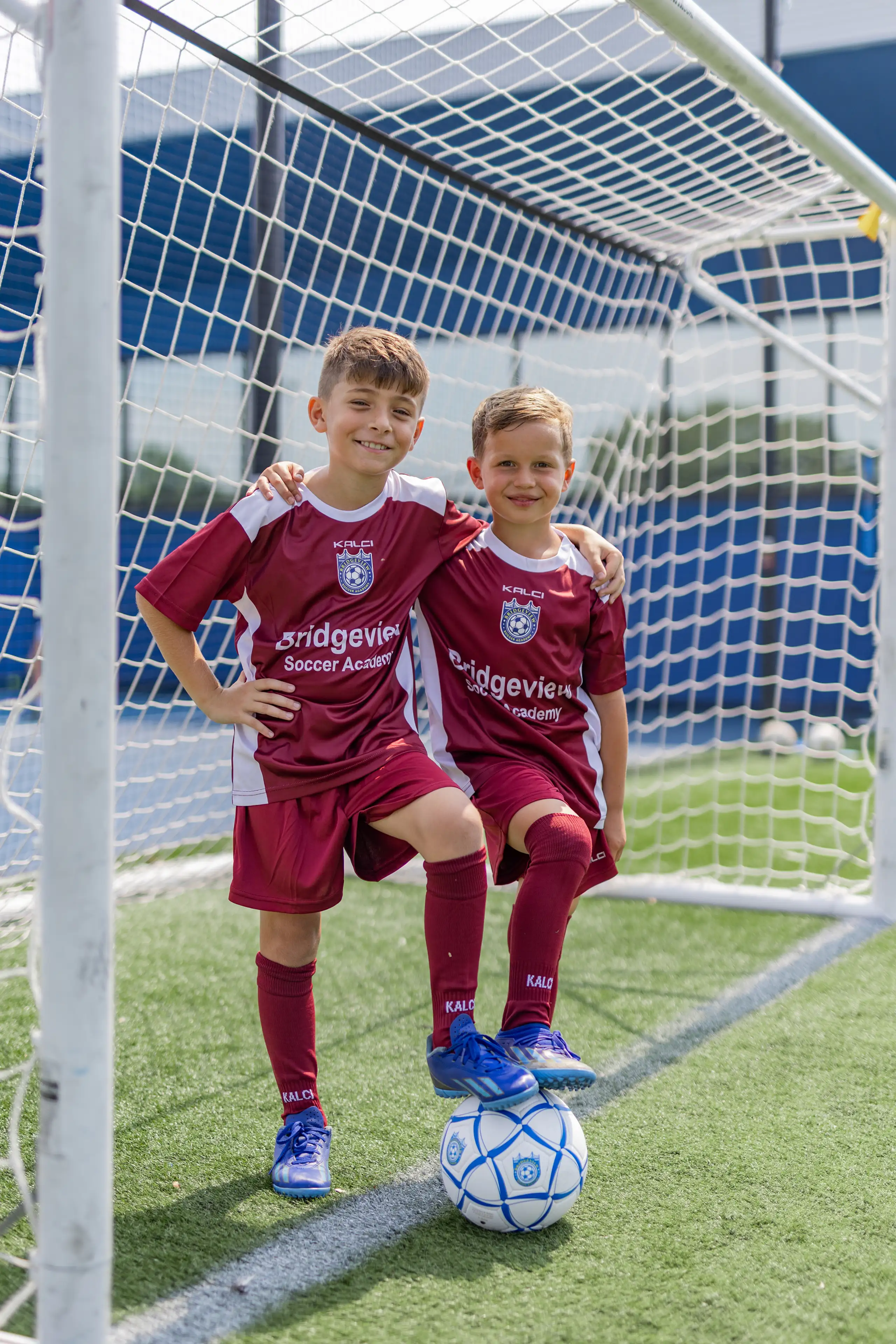 Young child smiling on the indoor turf at Bridgeview Soccer Academy